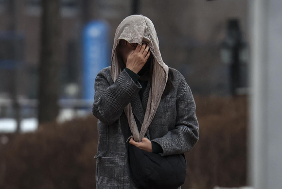 비가 내린 3일 오전 서울 영등포경찰서 인근에서 한 시민이 목도리로 머리를 감싼 채 이동하고 있다. [사진=뉴시스]