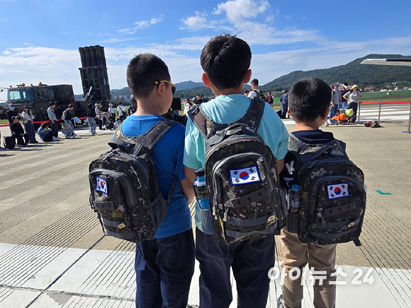 17일 서울공항에서 진행된 서울 국제 항공우주 및 방위산업 전시회(ADEX 2025) 'VR 패러글라이딩 체험존'에 사람들이 줄을 서있다. [사진=최란 기자]