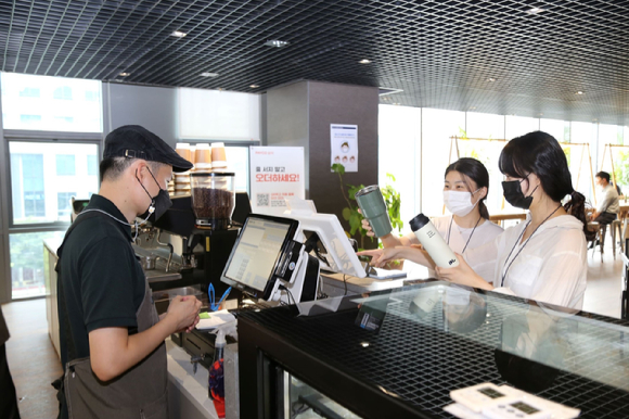 DL이앤씨 직원들이 서울 종로구 돈의문 디타워 내 D라운지카페에서 개인 컵을 사용해 음료를 주문하고 있다. [사진=DL이앤씨]
