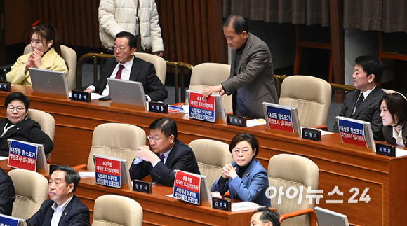 국민의힘 의원들이 9일 국회 본회의에서 국민의힘 나경원 의원이 가맹사업거래의 공정화에 관한 법률 일부개정법률안에 대해 무제한 토론을 하는 가운데 대장동 항소포기 국정조사 실시와 8대 악법 대국민 포기 선언을 촉구하는 인쇄물이 붙어 있다. [사진=곽영래 기자]