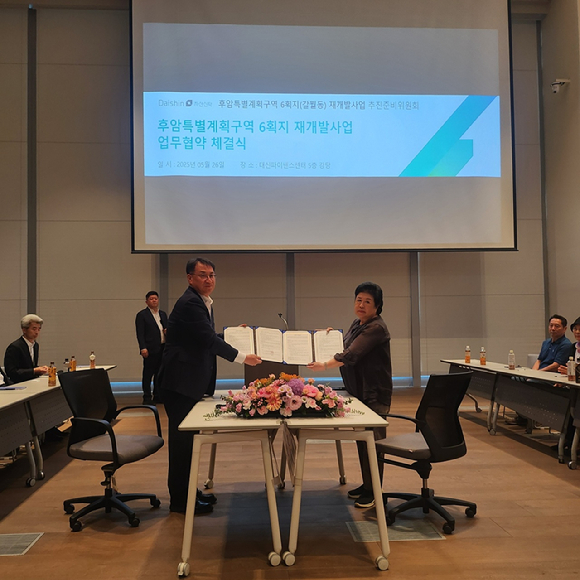 윤명숙 숙대입구 역세권 도시정비형 재개발사업 추진준비위원장(오른쪽)과 김송규 대신자산신탁 김송규 대표가 지난해 업무협약을 체결하고 기념사진을 촬영하고 있다. [사진=대신자산신탁 ]