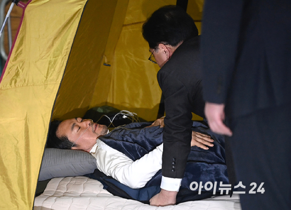 송언석 국민의힘 원내대표가 22일 서울 여의도 국회 로텐더홀 단식 농성장에 마련된 텐트 안에서 통일교&middot;공천헌금 '쌍특검' 수용을 요구하며 여드레째 단식 중인 국민의힘 장동혁 대표를 살펴보고 있다. [사진=곽영래 기자]