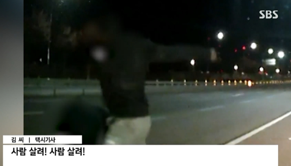 주한미군 A씨가 지난달 27일 오전 1시30분께 성남시 수정구의 한 도로에서 택시기사 B씨를 폭행하고 있다. [사진=SBS 캡처 ]