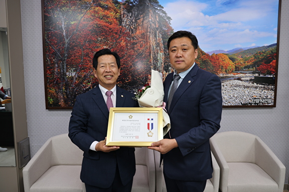 국민의힘 이상훈(오른쪽) 단양군의원이 대한민국 시군자치구의회 의장협의회가 수여하는 ‘지방의정 봉사상’을 수상했다. [사진=단양군의회]