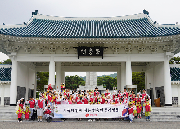 롯데건설 임직원과 가족들이 지난 27일 현충문 앞에서 봉사활동 후 기념촬영을 하고 있다. [사진=롯데건설]