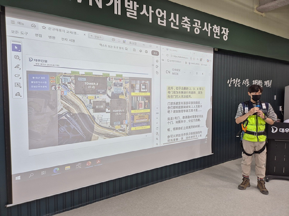 대우건설 관계자가 과천 G-TOWN 개발사업 신축공사 현장에서 외국인 근로자를 위한 AI 번역기 기능에 대해 교육 중이다. [사진=대우건설]