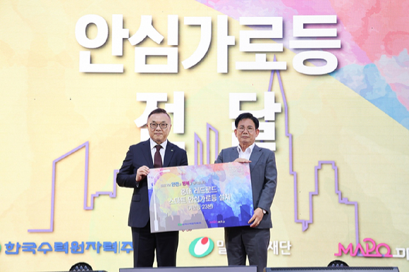 박강수 마포구청장(오른쪽)이 안심가로등 점등식에서 한국수력원자력 황주호 사장과 기념촬영을 하고 있다. [사진=마포구]