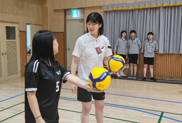 여자프로배구 흥국생명에서 아웃사이드 히터로 뛰고 있는 김다은(오른쪽)이 지난 12일 인천 갈산중학교 체육관에서 열린 '일일 유소년 배구교실'에 강사로 참여해 학생들을 대상으로 서브에 대해 알려주고 있다. [사진=흥국생명 핑크스파이더스 배구단]