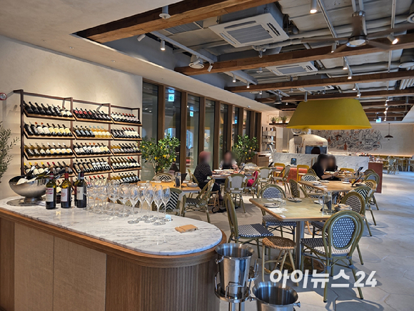올리페페 강남점 내부. 한쪽 벽면에는 와인이 진열돼 있고, 매장 중앙에는 대형 피자 화덕이 자리하고 있다. [사진=구서윤 기자]