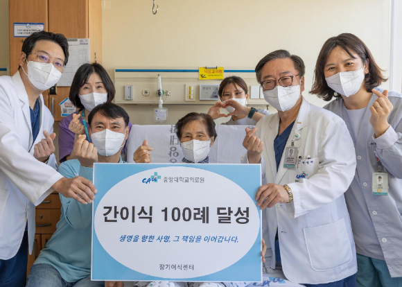 중앙대의료원 100번째 간 이식 수술을 마치고 기증자인 아들(사진 왼쪽에서 두 번째)과 수혜자인 어머니(사진 왼쪽에서 세 번째)가 의료진과 함께 건강한 모습으로 기념 촬영을 하고 있다. [사진=중앙대의료원]