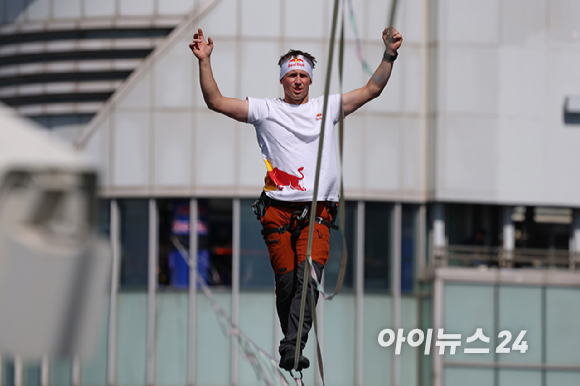 세계적인 슬랙라인 선수 얀 루스(Jaan Roose)가 1일 서울 광화문 사거리 상공 120m 높이에서 '레드불 서울 줄타기' 퍼포먼스를 선보이고 있다. [사진=정소희 기자]