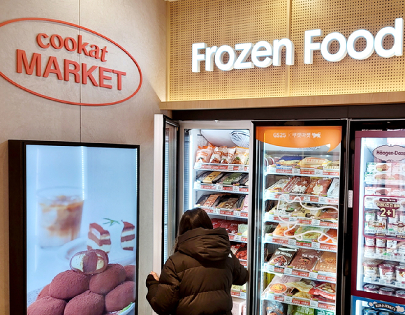 GS25합정프리미엄점에 시범 도입된 쿠캣 냉동매대에서 한 고객이 상품을 고르고 있다. [사진=GS리테일]