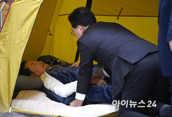 송언석 국민의힘 원내대표가 22일 서울 여의도 국회 로텐더홀 단식 농성장에 마련된 텐트 안에서 통일교&middot;공천헌금 '쌍특검' 수용을 요구하며 여드레째 단식 중인 국민의힘 장동혁 대표를 살펴보고 있다. [사진=곽영래 기자]