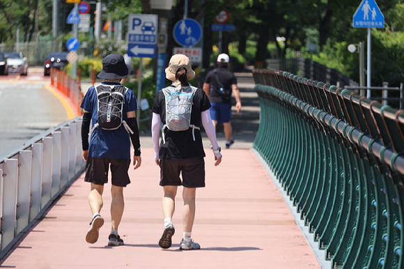 대전 한낮 기온이 30도에 육박하며 더운 날씨를 보인 10일 대전 대덕구 대청댐 산책로를 찾은 시민들이 걸으며 한여름의 정취를 즐기고 있다. 2025.8.10 [사진=연합뉴스]