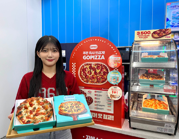 GS25에서 모델이 배달의민족과 협업해 출시한 피자를 들고 포즈를 취하고 있다. [사진=GS리테일]
