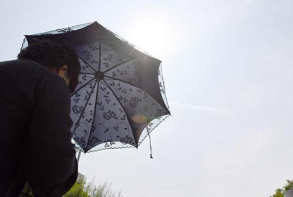 광주 서구 풍암호수공원에서 한 시민이 햇빛을 피하기 위해 양산을 쓰고 있다. 본 기사 내용과 상관없는 사진. [사진=뉴시스]