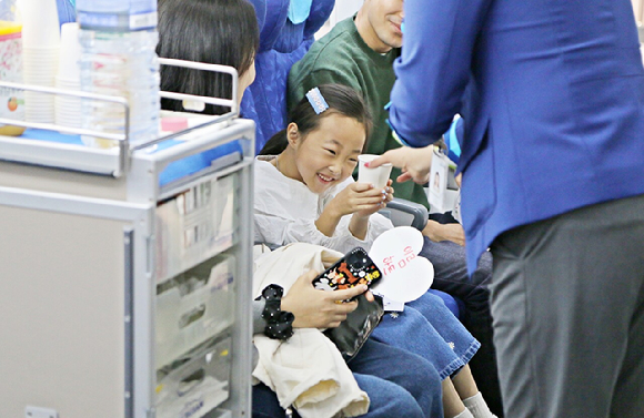 16일 오전 에어부산 본사에서 진행된 가족 초청 '패밀리데이' 행사에 참여한 임직원 자녀가 기내 서비스 체험을 하고 있다. [사진=에어부산]