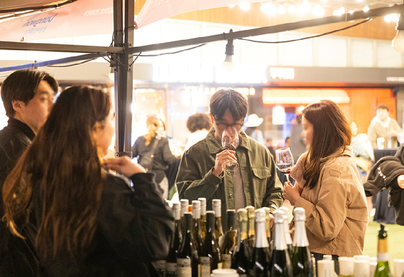 방문객들이 '남산 와인페어' 현장에서 와인을 시음하며 제품 설명을 듣고 있다. [사진=CJ푸드빌 제공]