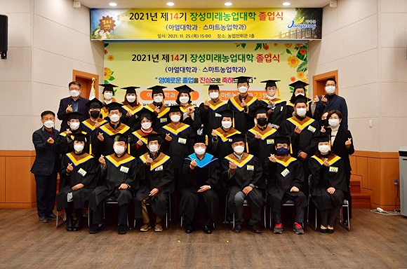 제14기 장성미래농업대학 졸업식에서 학사모를 입은 졸업생들과 관계자들이 화이팅을 하고 있다. [사진=곡성군]