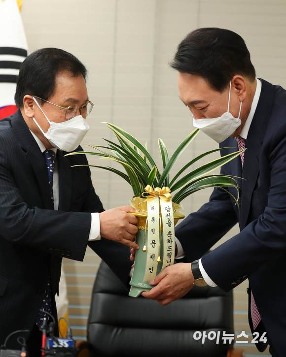 윤석열 대통령 당선인이 10일 오후 서울 여의도 국민의힘 당사에서 유영민 대통령 비서실장에게 문재인 대통령의 축하난을 받고 있다. [사진=김성진 기자]