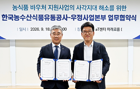정철중 우정사업본부 우편사업단장(오른쪽)이 지난 18일 서울aT센터에서 기운도 한국농수산식품유통공사(aT) 유통이사와 농식품 바우처 지원을 위한 업무협약을 체결하고 있다. [사진=우정사업본부]