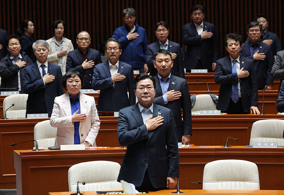 더불어민주당 박찬대 원내대표를 비롯한 의원들이 4일 국회에서 열린 긴급 의원총회에서 국기에 경례를 하고 있다. 2025.5.4 [사진=연합뉴스]