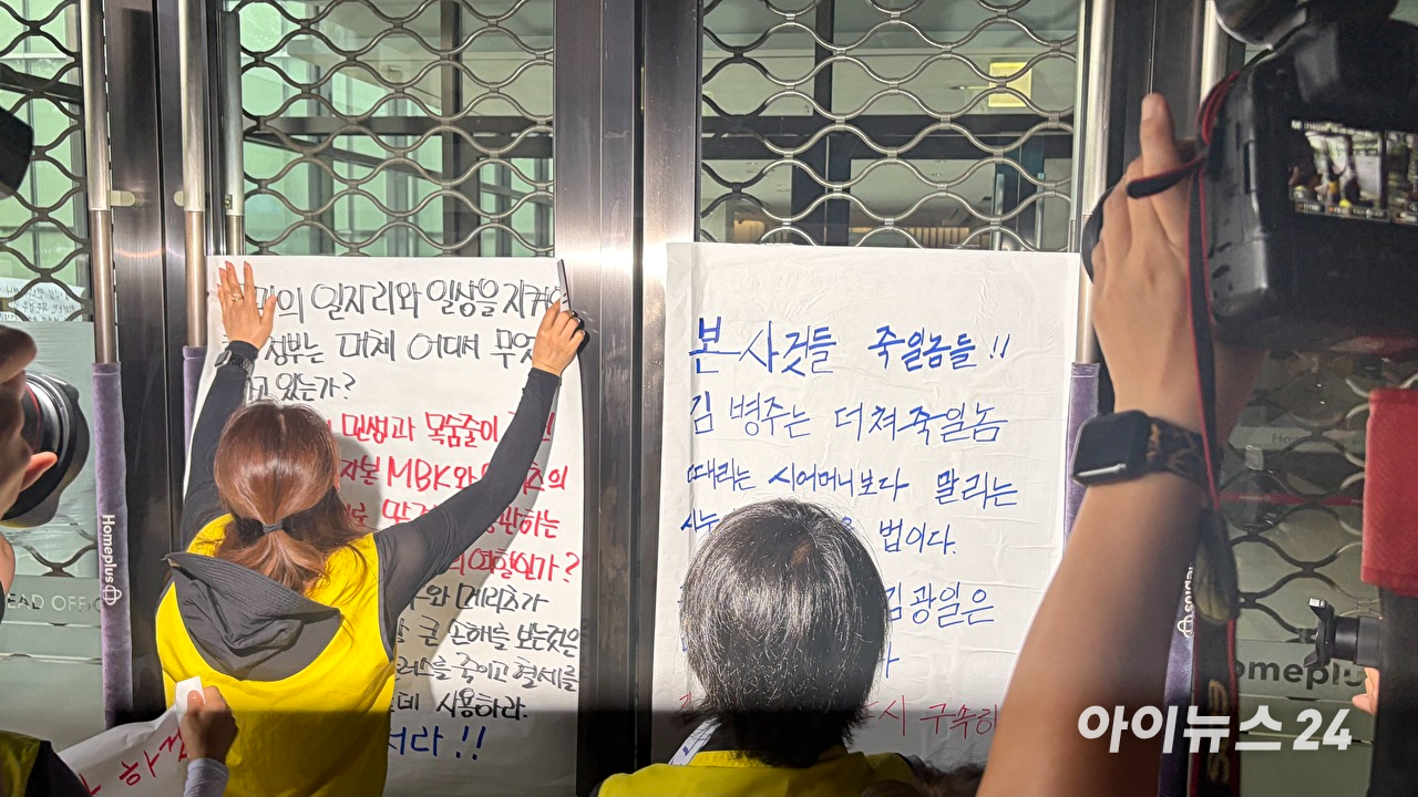 지난 14일 마트노조가 서울 강서구 홈플러스 본사 입구 외벽에 규탄문을 붙이고 있다. [사진=진광찬 기자]