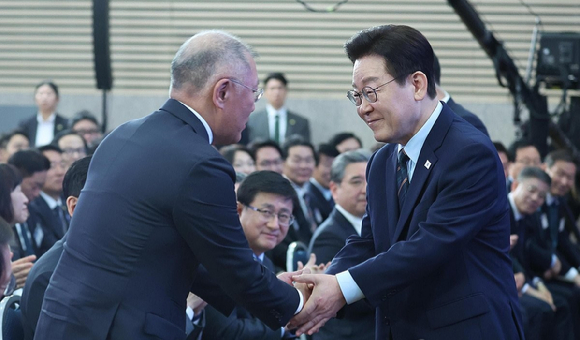 이재명 대통령이 27일 전북 군산새만금컨벤션센터에서 열린 새만금 로봇&middot;수소&middot;AI 시티 투자협약식에서 축사를 마친 뒤 정의선 현대차그룹 회장과 악수하고 있다. [사진=연합뉴스]