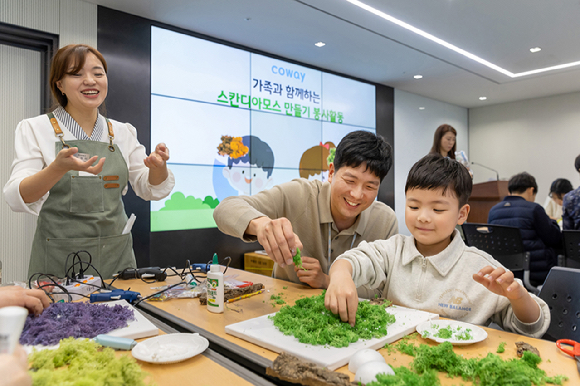 코웨이 임직원 자원봉사자와 가족들이 스칸디아모스 공기정화 액자를 제작하고 있다. [사진=코웨이]