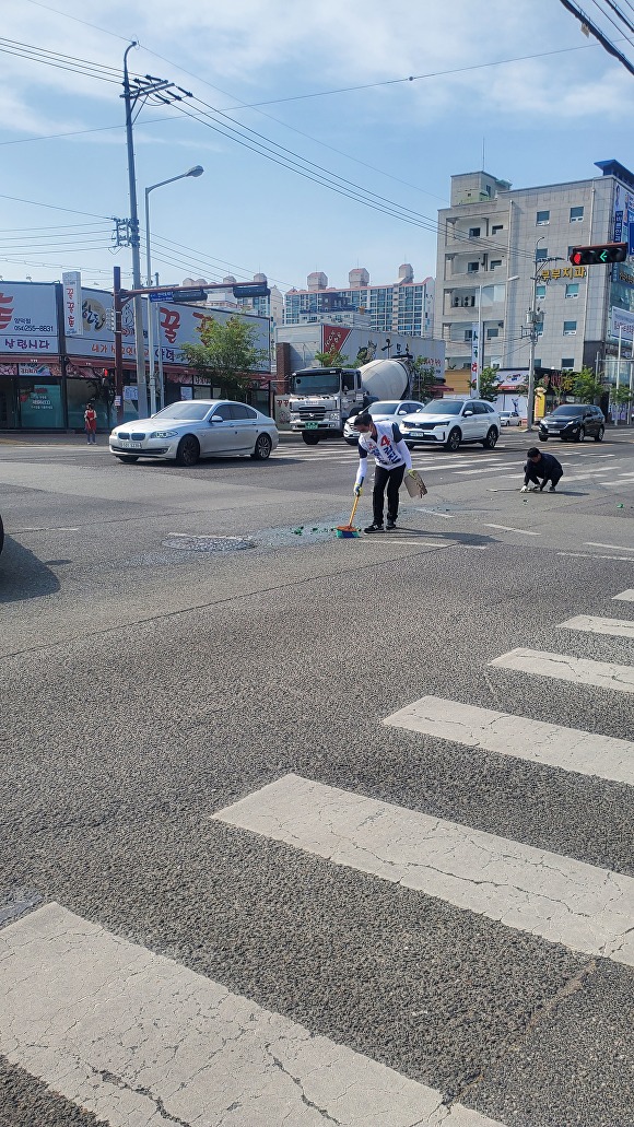 20일 오후 3시 40분쯤 김진율 무소속 포항시의원 후보가 도로에 떨어진 소주병 유리조각을 청소하고 있다. [사진=시민제보]