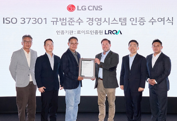 LG CNS CEO 현신균 사장(왼쪽에서 세번째)과 로이드인증원 글로벌커머셜어드바이저 스튜어트 켈리(오른쪽에서 세번째) 및 관계자들이 인증 수여식에서 사진 촬영하는 모습. [사진=LG CNS]