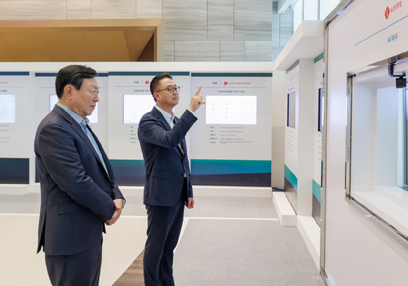 롯데는 15일 롯데월드타워에서 '2026 하반기 VCM'을 개최했다. 본 회의에 앞서 그룹 AX 추진 현황 및 사례를 소개하는 'AI 에이전트 전시'를 진행했다. 신동빈 롯데 회장(왼쪽)이 황민재 롯데지주 경영혁신실장(오른쪽)으로부터 음성과 모션 인식 기반 'AI 비서'에 대한 설명을 듣고 있다. [사진=롯데]