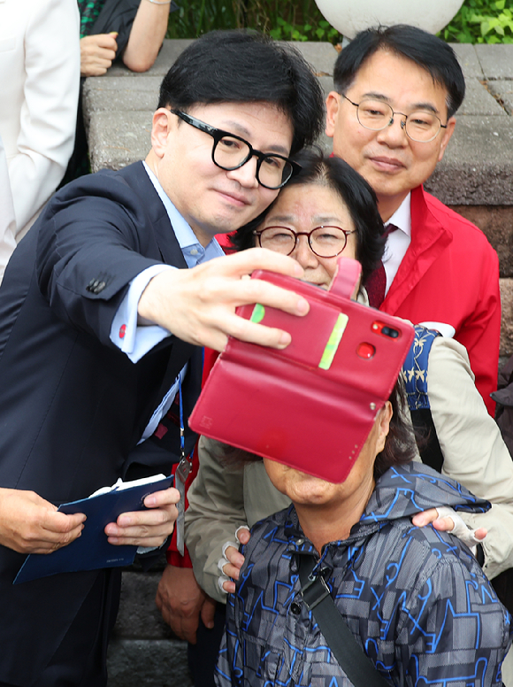 국민의힘 한동훈 대표가 6일 오전 부산 금정구 남산성당 앞에서 신도들과 사진을 찍으며 윤일현 금정구청장 보궐선거 후보 지지를 호소하고 있다. 2024.10.6 [사진=연합뉴스]