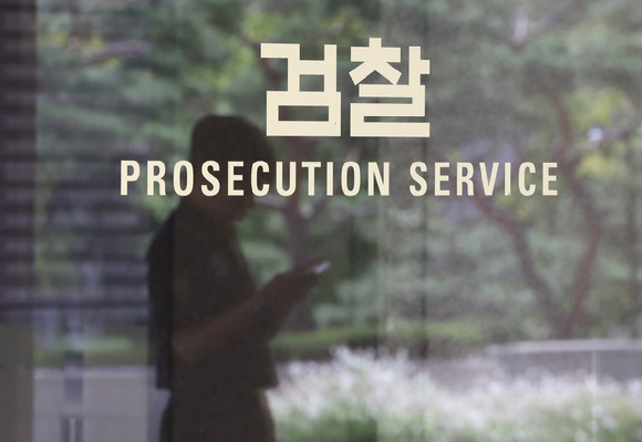 직원이 살해된 경기 시흥시의 한 편의점 앞에 추모의 글귀가 적힌 쪽지와 국화 꽃다발, 간식 등이 놓여있다. [사진=연합뉴스]