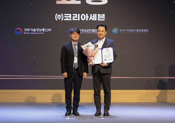 지난 1일 서울 SC컨벤션센터에서 개최된 '2025 전자문서 산업인의 날' 행사에서 문대우(오른쪽) 세븐일레븐 디지털혁신부문장이 부총리 겸 과학기술정보통신부장관 표창 수상 후 엄열 과학기술정보통신부 국장과 기념촬영을 하고 있다. [사진=세븐일레븐]