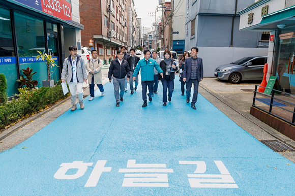 박강수 마포구청장 등이 하늘색으로 칠해진 합정 하늘길 도로를 걷고 있다. [사진=마포구]