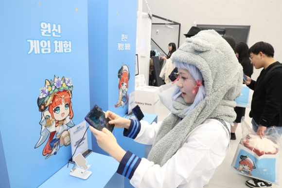 한 여성 고객이 삼성 강남 '원신 프리미엄 라운지'에서 '갤럭시 Z 폴드5'로 원신 게임을 즐기고 있다. [사진=삼성전자]