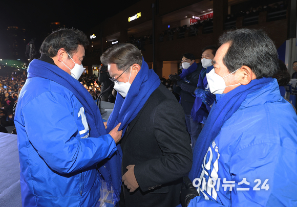 이재명 더불어민주당 대선후보가 제20대 대통령 선거 공식 선거운동이 시작된 15일 서울 강남고속버스터미널 광장에서 집중 유세 중 이낙연 총괄선대위원장에게 파란색 목도리를 전달받고 있다. [사진=국회사진취재단]