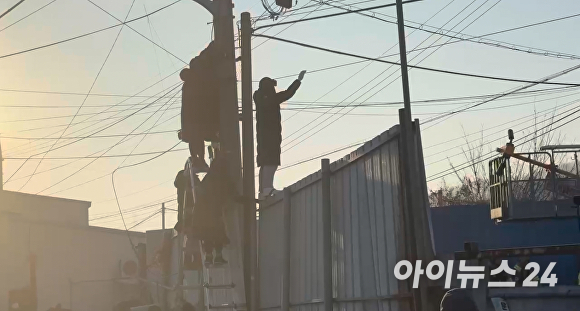 용주골 종사자들이 지난 30일 파주 시청에서 전봇대에 감시카메라를 설치 하는 집행을, 전선을 잡고 시위하고 있다. [사진=이윤택]