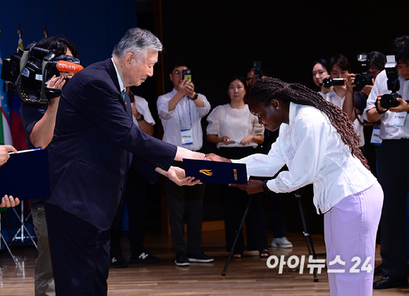 이중근 부영그룹 회장 겸 우정교육문화재단 이사장이 26일 서울 중구 대한상공회의소 국제회의장에서 열린 '2026년 제2학기 장학금 수여식'에 참석해 장학생 대표 카자흐스탄 아이가늠 자리너바와 인사를 나누고 있다. [사진=정소희 기자]