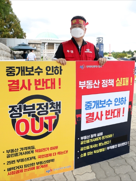 서울 영등포구 국회 앞에서 한국공인중개사협회 회원이 중개보수 인하 결사 반대를 촉구하며 1인 시위를 하고 있다.  [사진=뉴시스]