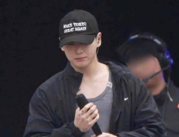 그룹 방탄소년단(BTS)의 멤버 정국이 13일 경기 고양시 서구 고양종합운동장 주경기장에서 '도쿄를 다시 위대하게(MAKE TOKYO GREAT AGAIN)'라는 문구가 적힌 모자를 착용한 채 리허설을 하고 있다. [사진=온라인 커뮤니티]