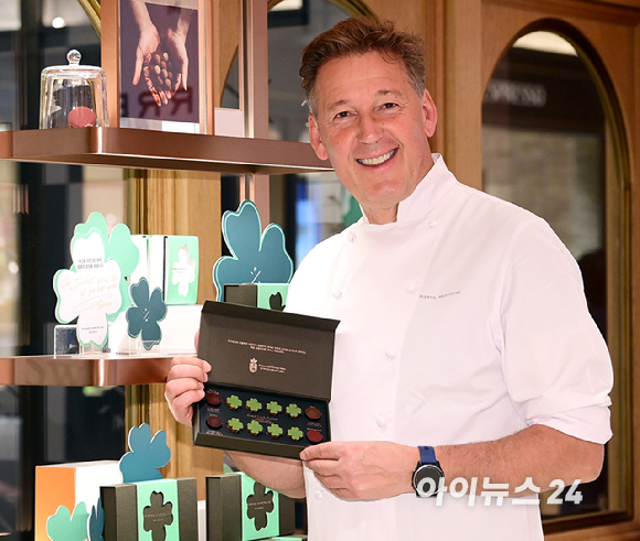 벨기에 초콜릿 브랜드 피에르 마르콜리니(Pierre Marcolini)가 수능을 앞둔 한국 수험생을 위한 시즌 한정 초콜릿 '그랑 클로버 셀렉션'을 출시한 가운데 16일 신세계백화점 강남점 스위트파크 내 피에르 마르콜리니 매장에서 브랜드 파운더 피에르 마르콜리니가 제품을 들고 포즈를 취하고 있다. [사진=정소희 기자]