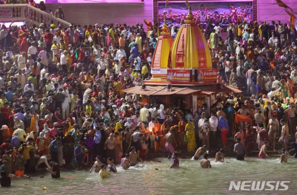 12일(현지시간) 인도 북부 우타라칸드주 하르드와르에서 힌두교 최대의 성지 순례 축제인 '쿰브멜라'(Kumbh Mela)가 열려 마스크를 착용하지 않고 사회적 거리 두기를 무시한 신자들이 갠지스강에서 몸을 씻고 있다. [사진=뉴시스]