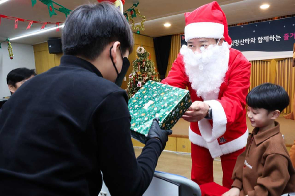 홍범식 LG유플러스 사장이 희망산타로 변신해 어린이에게 선물을 전달하는 모습. [사진=LGU+]