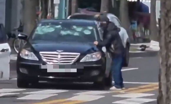 도로 한복판에서 차량 앞유리 등에 고무망치를 휘두른 50대 남성이 경찰에 붙잡혔다. 사진은 A씨 범행 모습. [사진=온라인 커뮤니티]