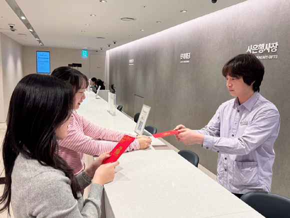 롯데백화점 본점 사은행사장에서 춘절 기념 홍바오(붉은 봉투)에 상품권을 증정하는 모습. [사진=롯데백화점]