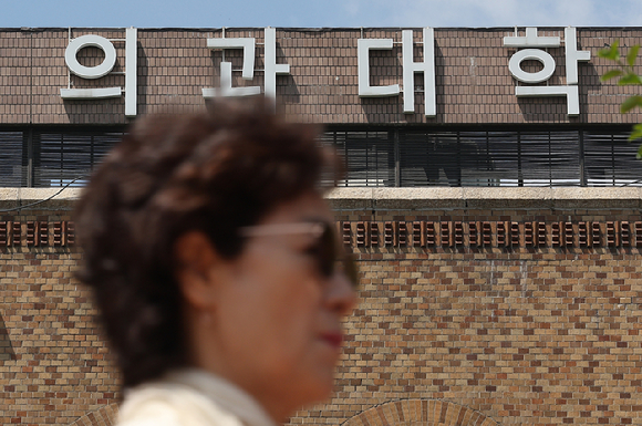 지난 7일 오전 한 시민이 서울 시내 한 의과대학 앞을 지나가고 있다. [사진=연합뉴스]