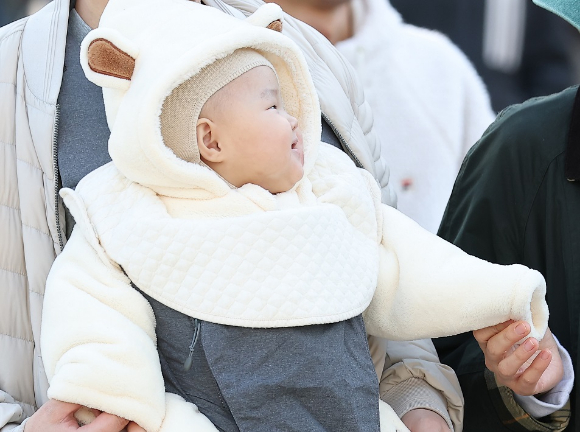 초겨울 날씨가 나타난 가운데 서울 종로구 광화문광장 인근 횡단보도에서 아기를 안은 가족이 이동하고 있다. [사진=연합뉴스]