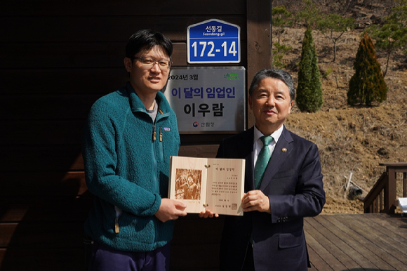 남성현 산림청장(오른쪽)이 14일 경북 예천군 용문면에서 3월 '이달의 임업인'으로 선정한 이우람 은솔농장 대표를 포상한 뒤 함께 기념촬영하고 있다. [사진=산림청]